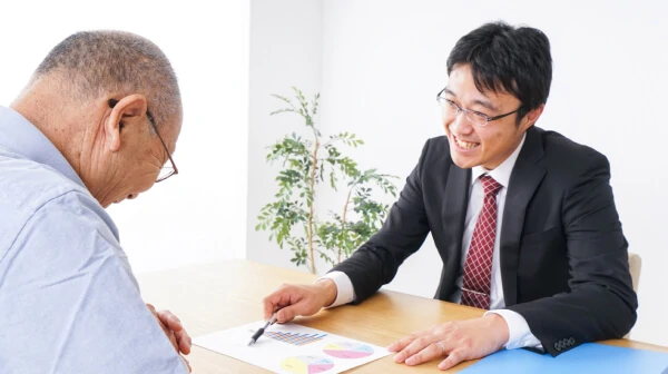 画像:スーツの男性が高齢のお客様に説明している様子