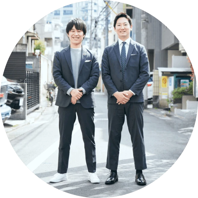 写真:男性二人が手を組んで並んで立っています。左：代表取締役　市川 力 、右：取締役　箭内 祥平